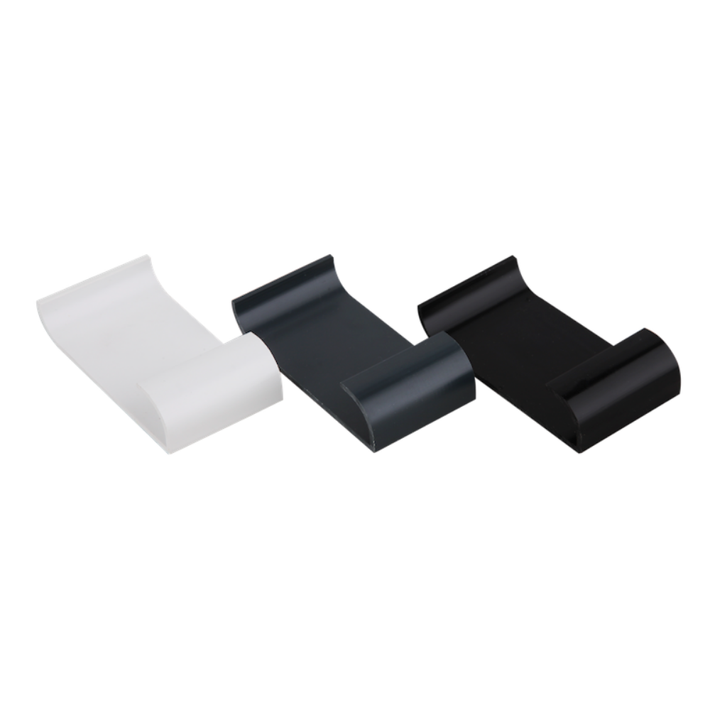 A white, an antrachite grey, and a black gutter trim clip lying face up.