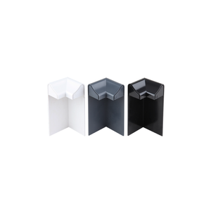 A white, an anthracite grey, and a black external edge trim corner, standing upright to emphasise their shape and colour.